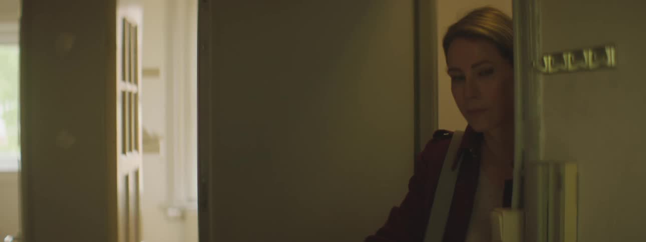 A woman standing in the doorway in a house