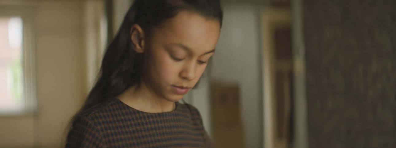 A young girl runs out of a room in her house