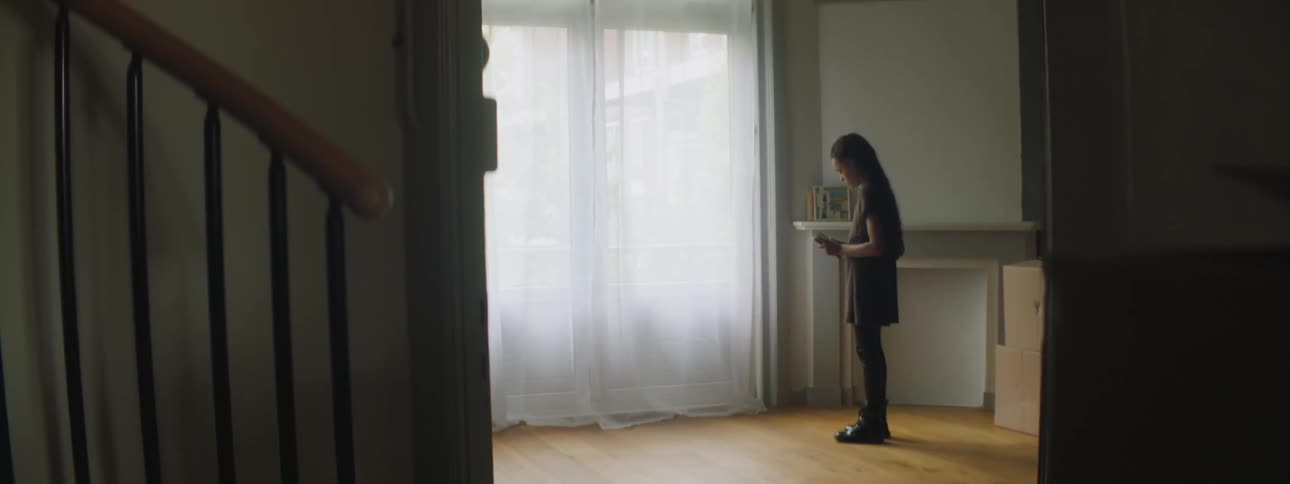A girl runs in and out of the living room