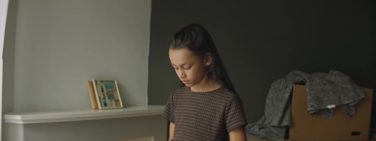 A young girl looks at a photo at home