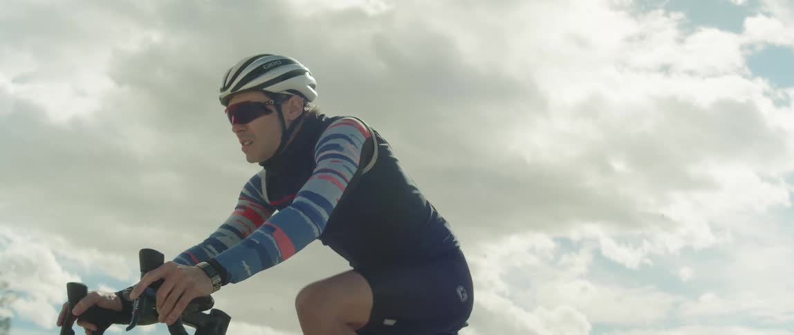 A man leans forward while riding a bicycle