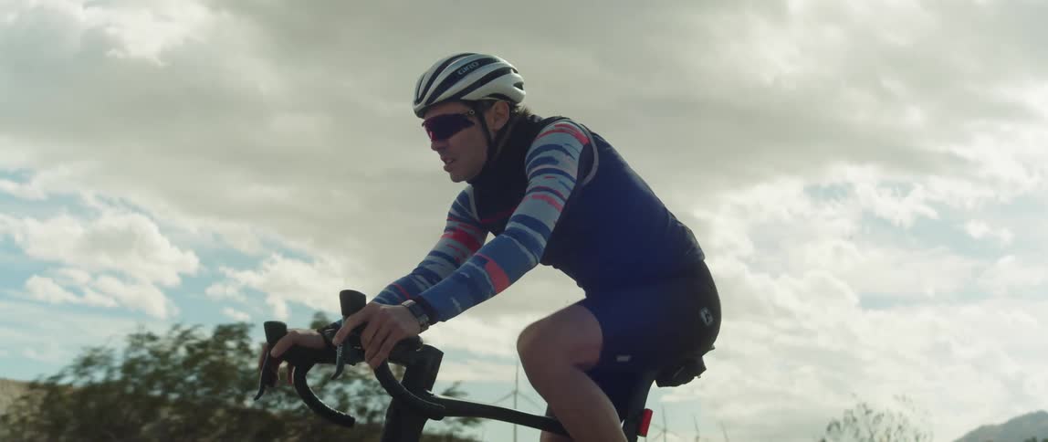 A man strains as he pedals a bike uphill