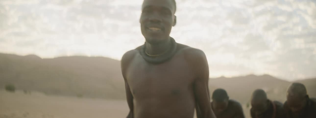 People cheer as a man dances in the desert