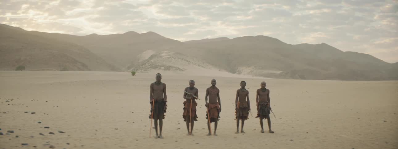 Members of a tribe standing in a desert