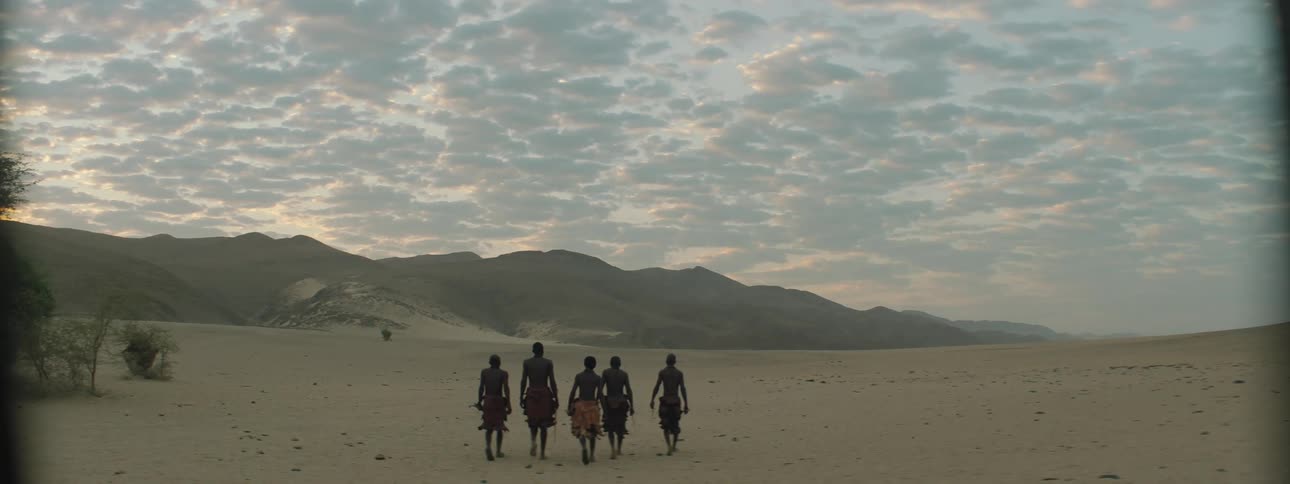 Members of a tribe walk across the landscape