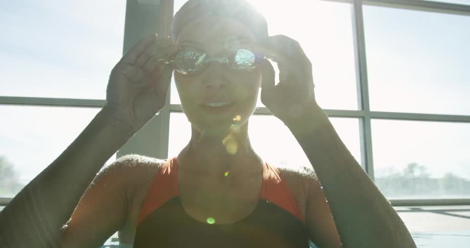 A woman smiles and adjusts her goggles