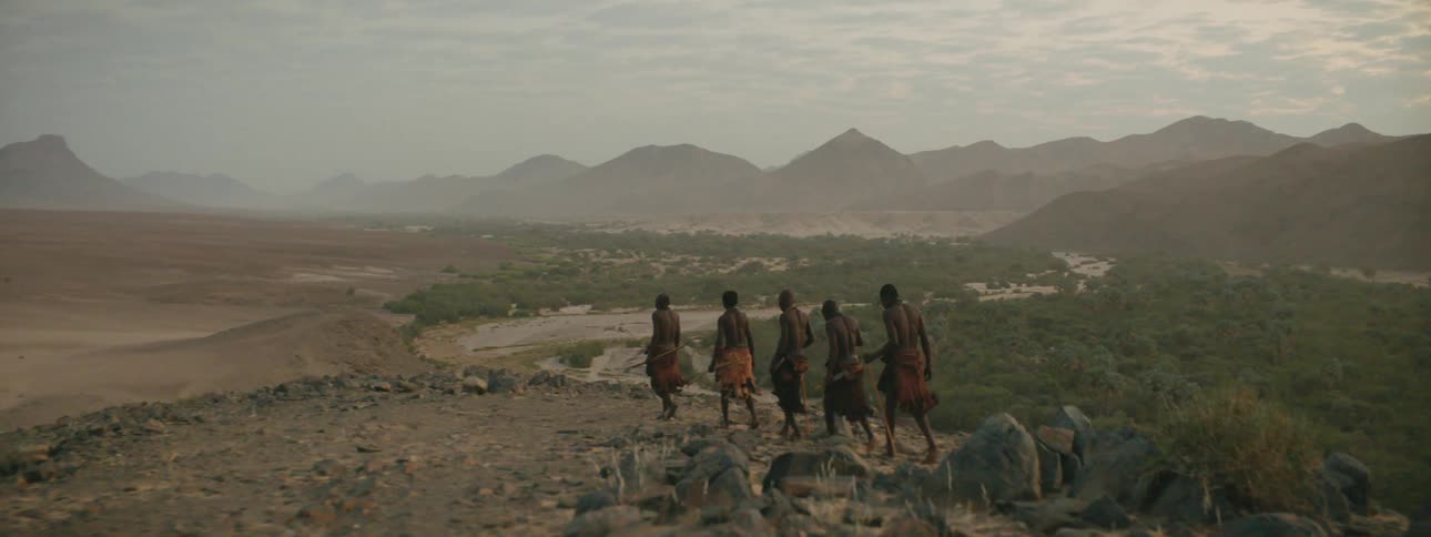 Men in a tribe walking across the land