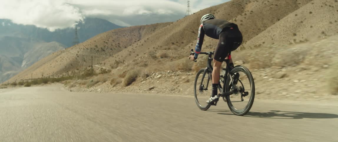 A man is riding his bike on the path