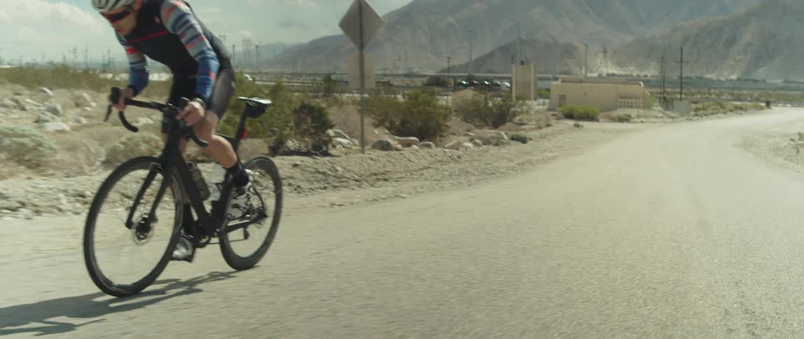 A man is riding his bicycle outdoors during the day