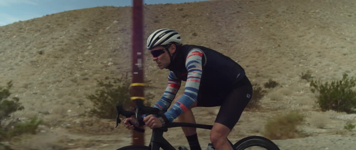A man riding a bicycle on a desert road in the daytime