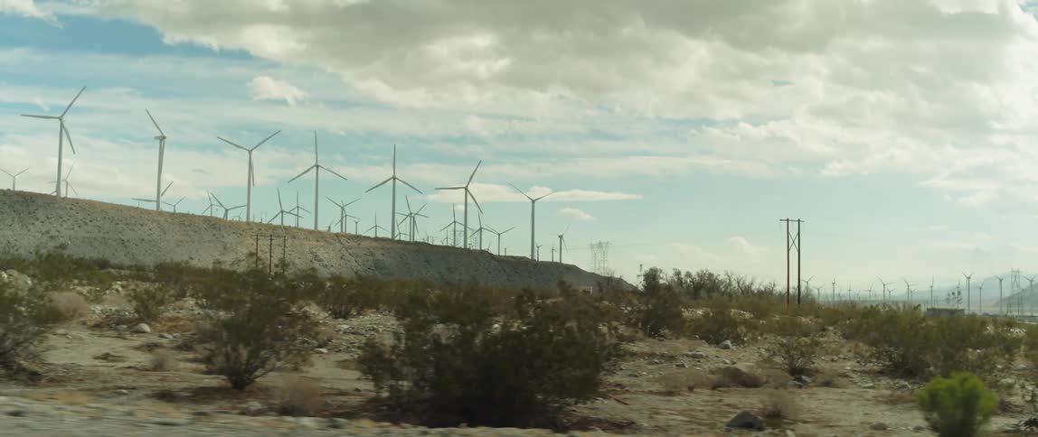 Turbines spinning on a wind farm on the hills of a desert