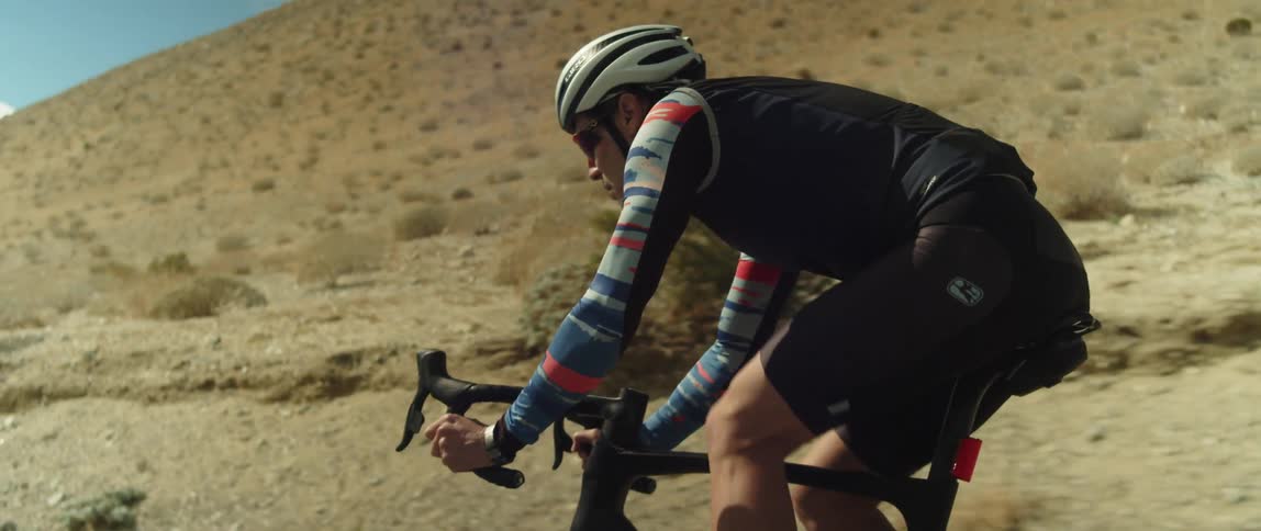Cyclist riding bicycle across the desert