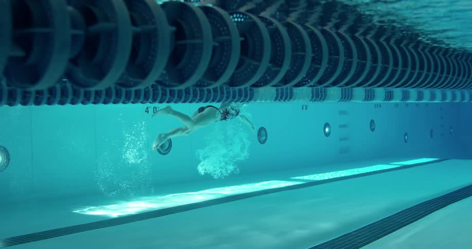 A woman is swimming in the water of a pool