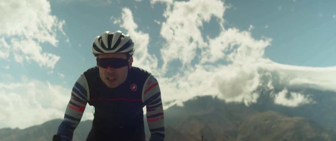 A man pedals hard while cycling through the countryside during the day