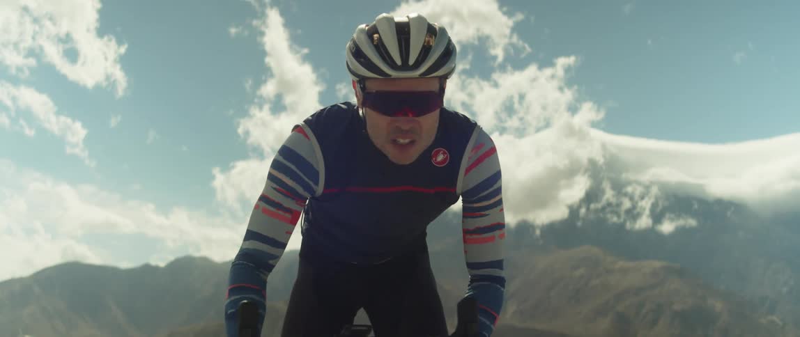 A man pedals hard while cycling through the countryside during the day