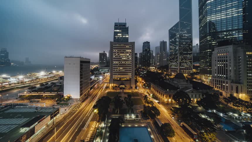A time lapse shows a city by the river in the day to the night time