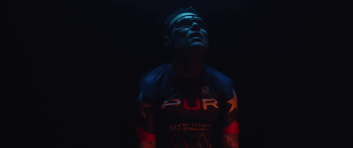 A man wearing a jersey looks up as he rests