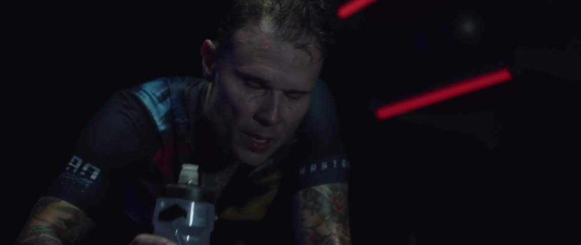 An exercising man takes a drink from a water bottle