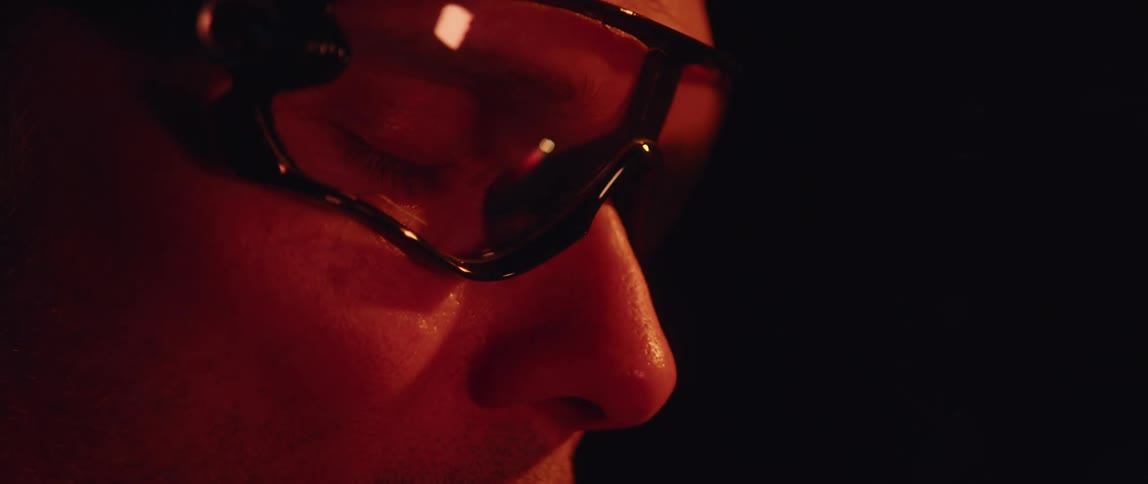 A close up of a man wearing goggles in darkness