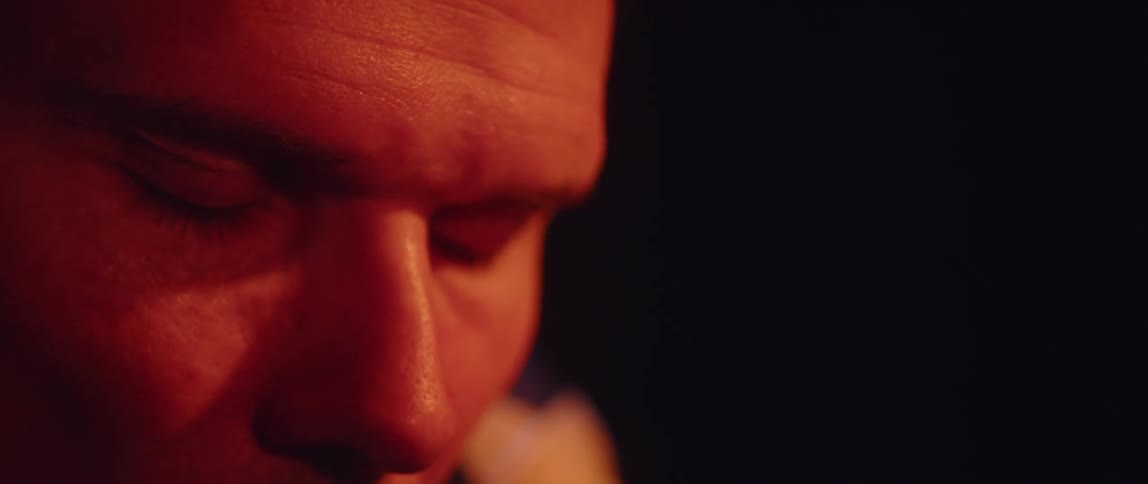 Close up of the eyes and forehead of a man inside a dimly lit room