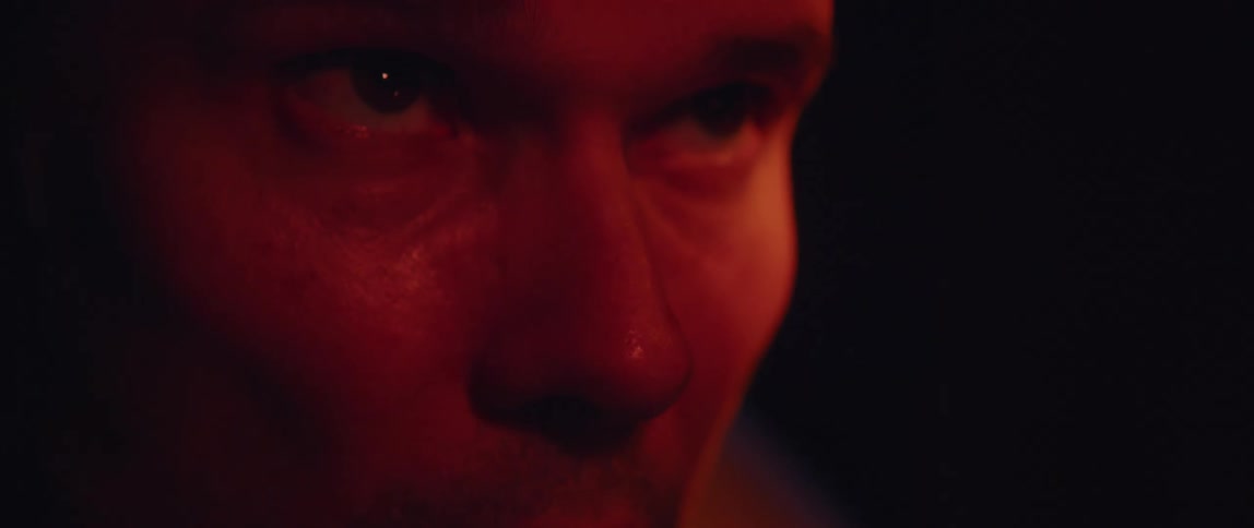 A mans face with furrowed brow looking like hes straining and sweating
