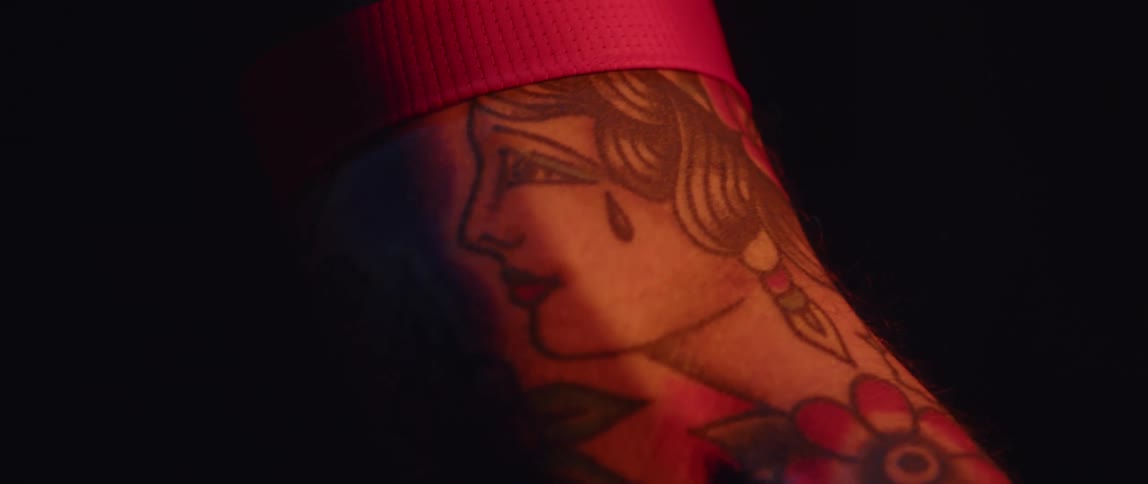 A tattoo of a woman with a flower is on a persons arm