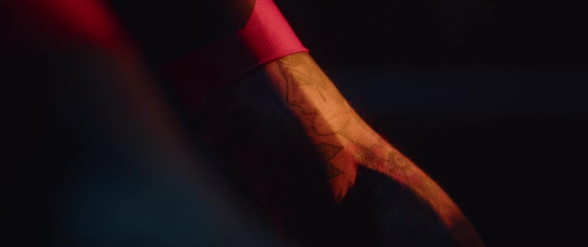 A tattooed man riding a stationary bike