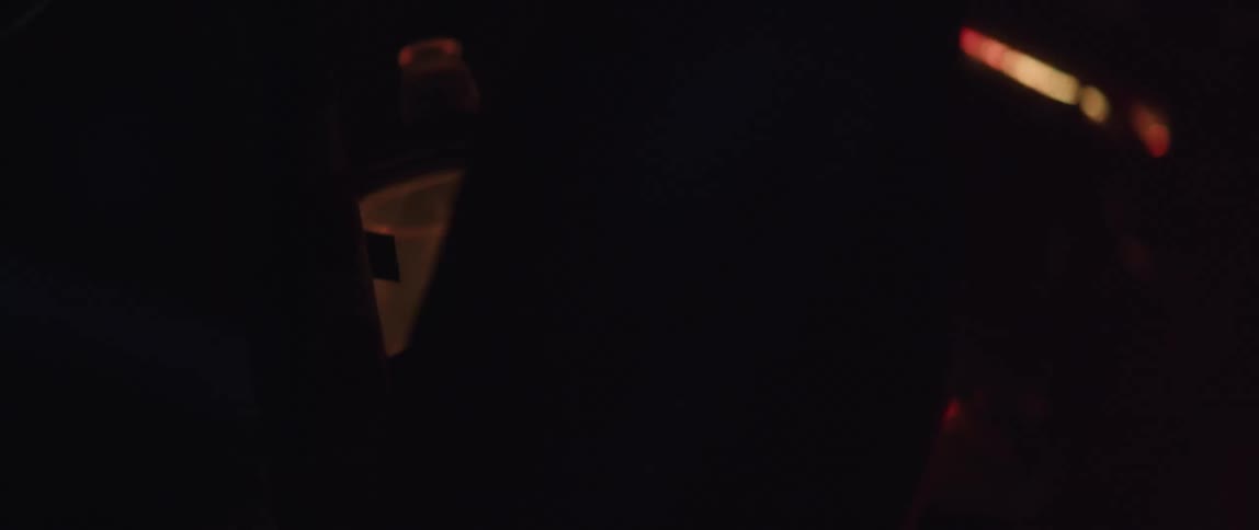 A persons legs are pedaling a bike in the dark