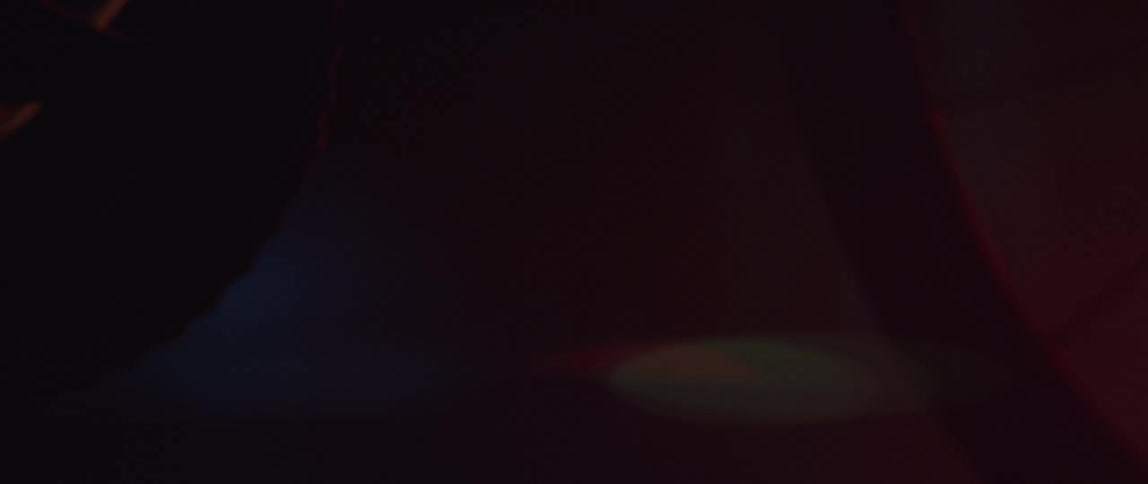 Close up of foots spinning the pedals of a bicycle inside a dimly lit room