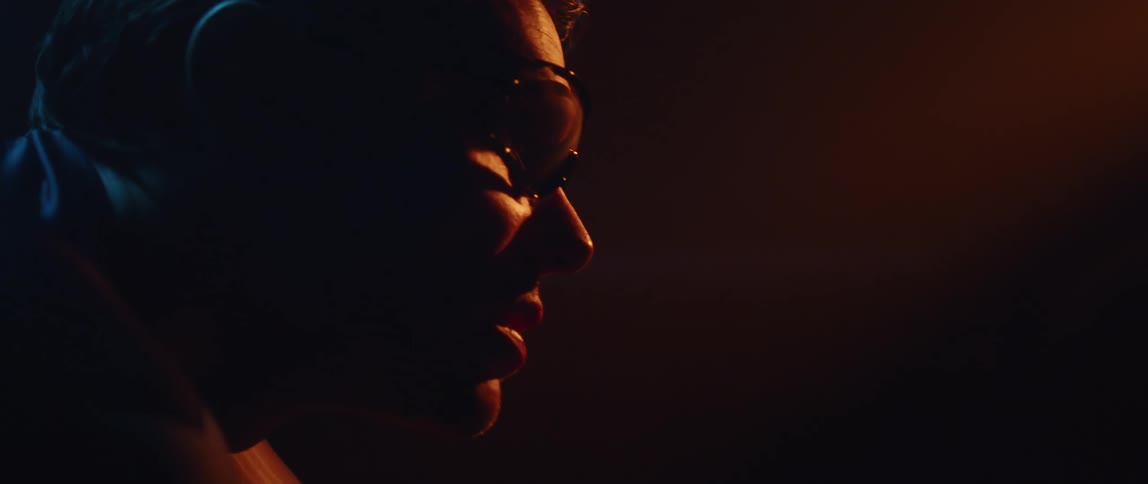 A man is looking forward in the dark room