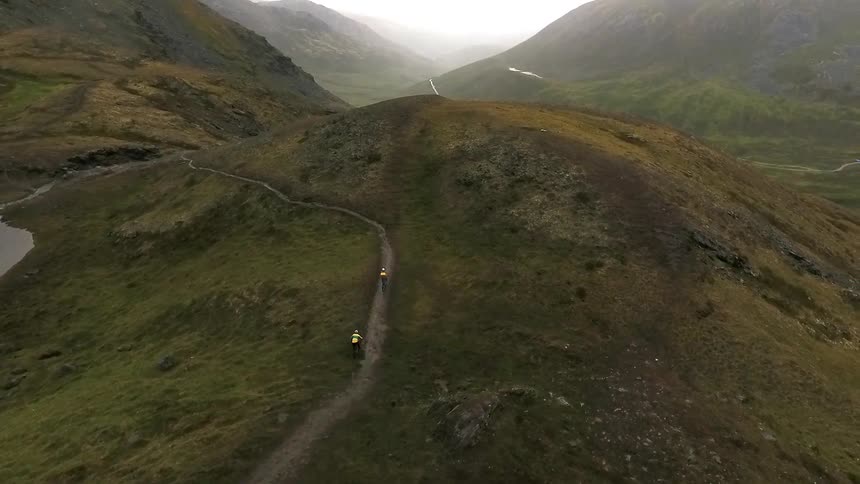 People riding mountain bikes along a mountain trail