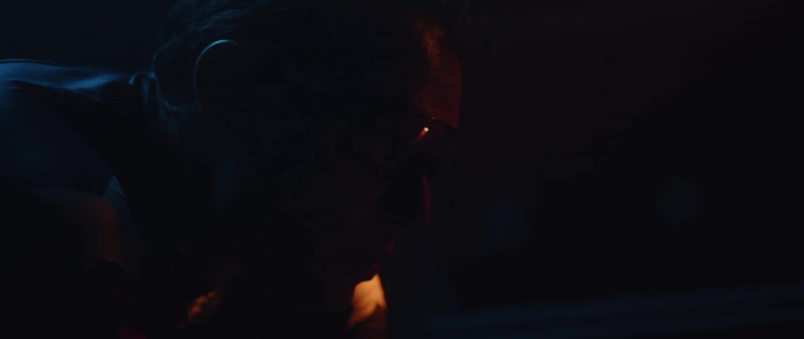 A man has his head down as he waits in the dark