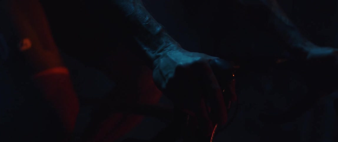 Close up of the hands of a man gripping the handlebar of a bicycle under blue lights