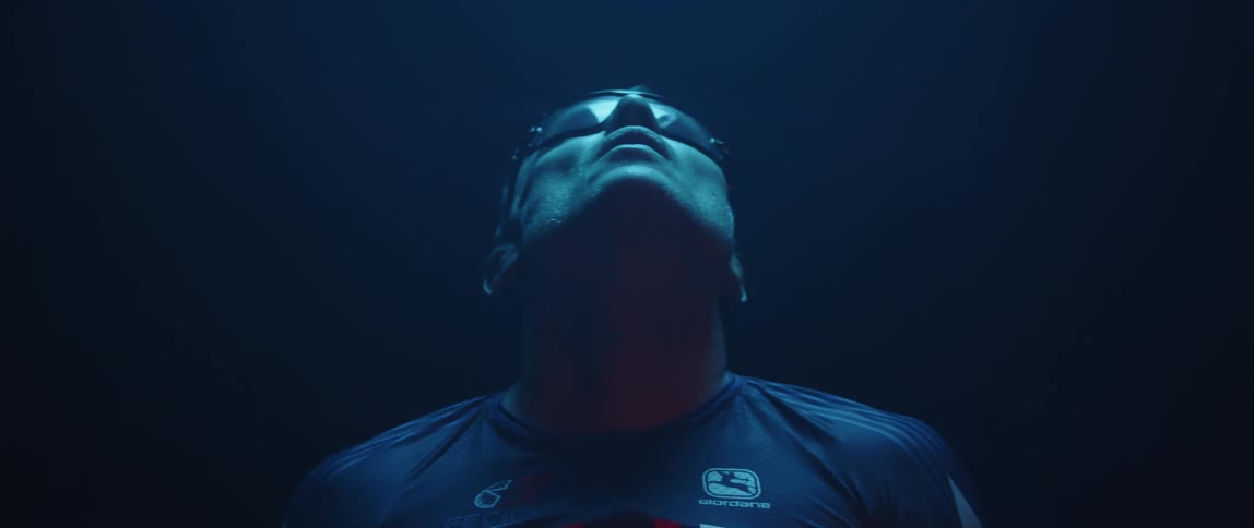 A man is wearing glasses and standing outdoors at night