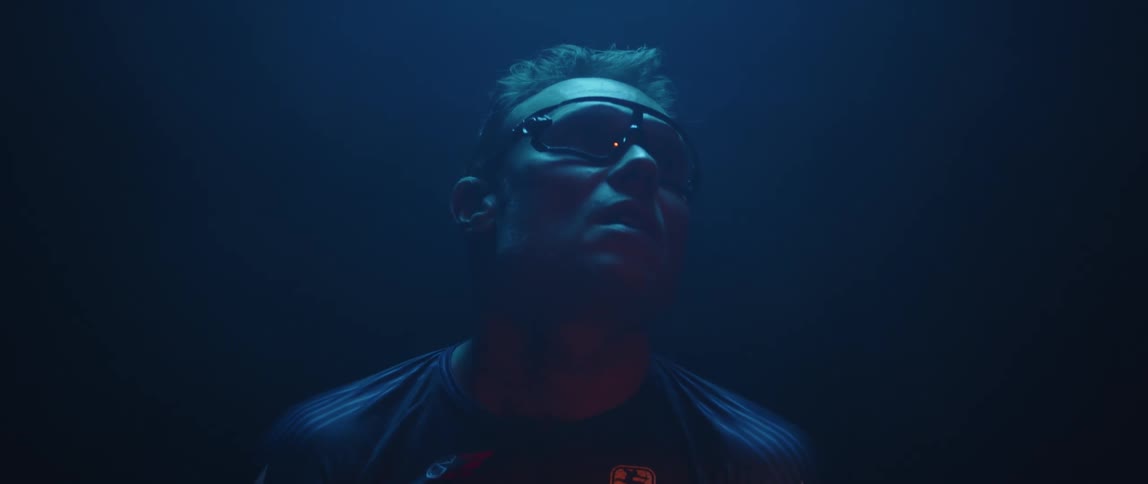 Man wearing protective glasses looks up inside a room under blue lights