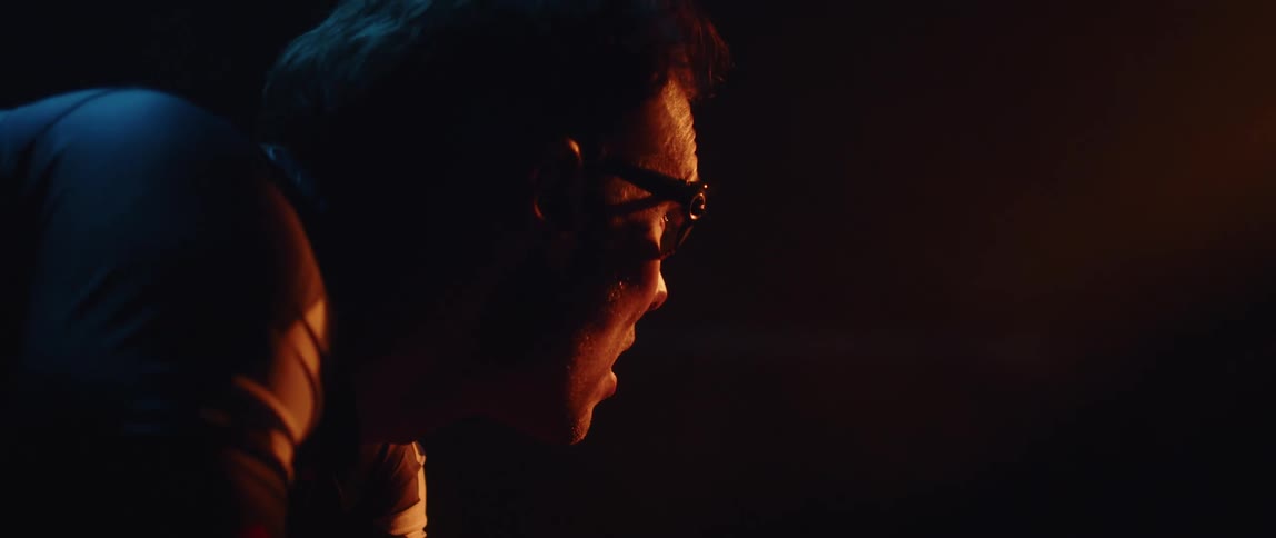 A man is leaning in the dark room