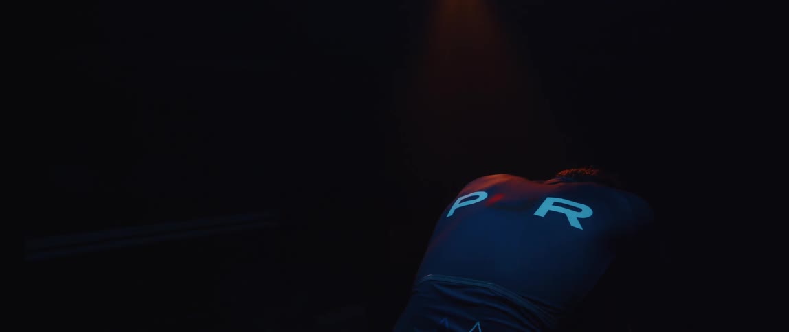 Determined male cyclist with jersey shirt and tattoos pedals exercise bike