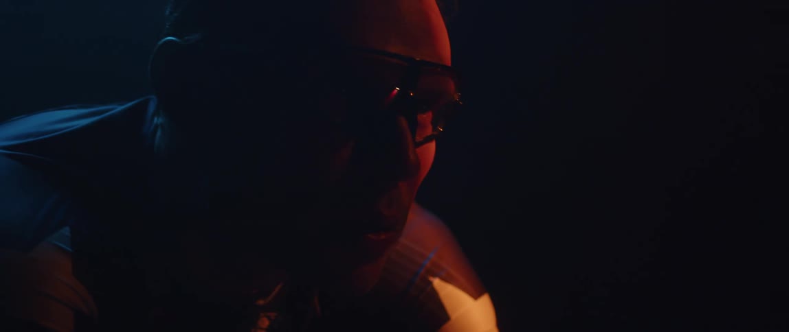 A man is wearing glasses outdoors during night time