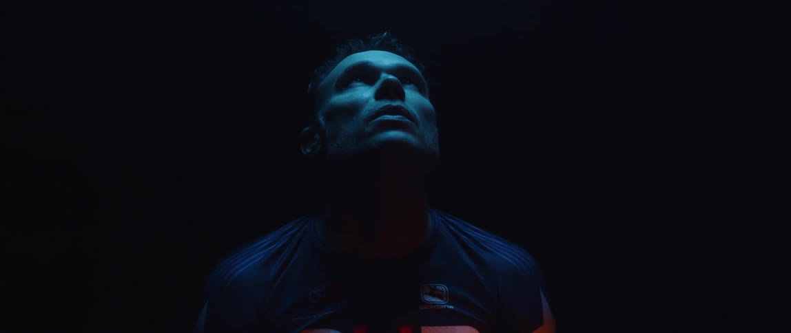 Man looks up inside a room under blue lights