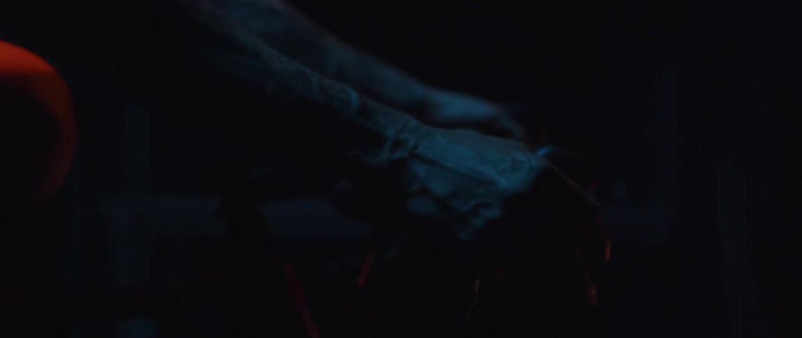 Close up of the hands of a man gripping the handlebar of a bicycle under blue lights