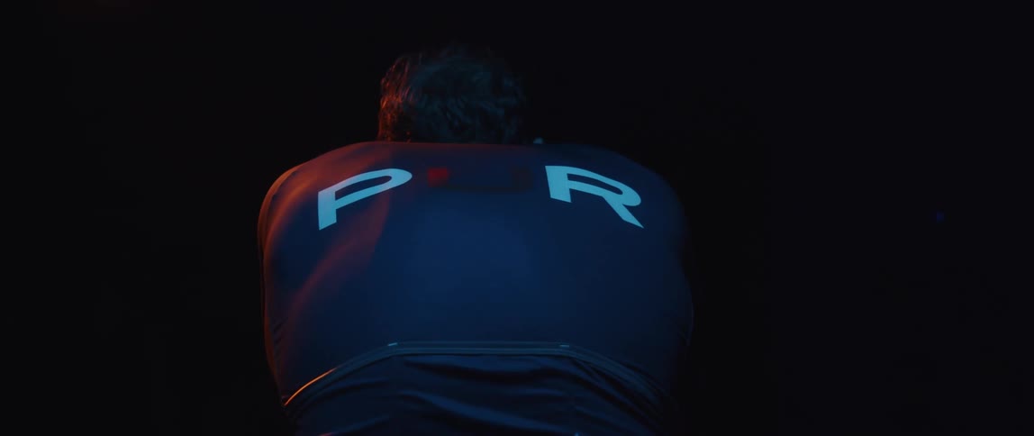 A man riding a stationary bike in darkness