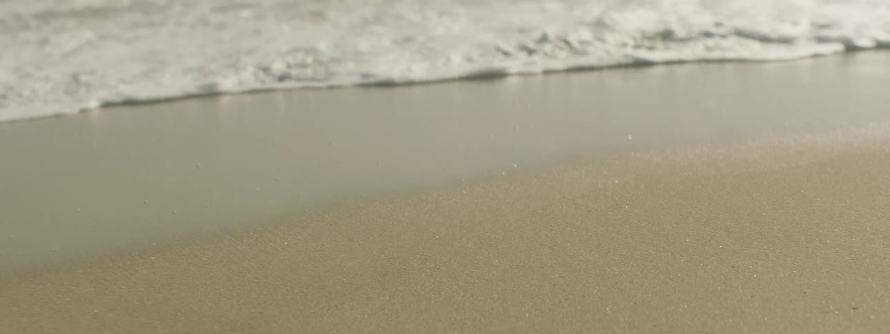 Ocean water is moving towards the coast of the beach