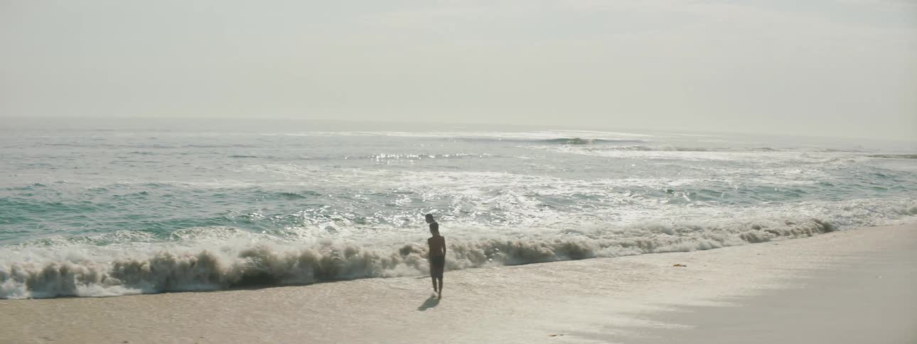 Two children play together in incoming ocean waves