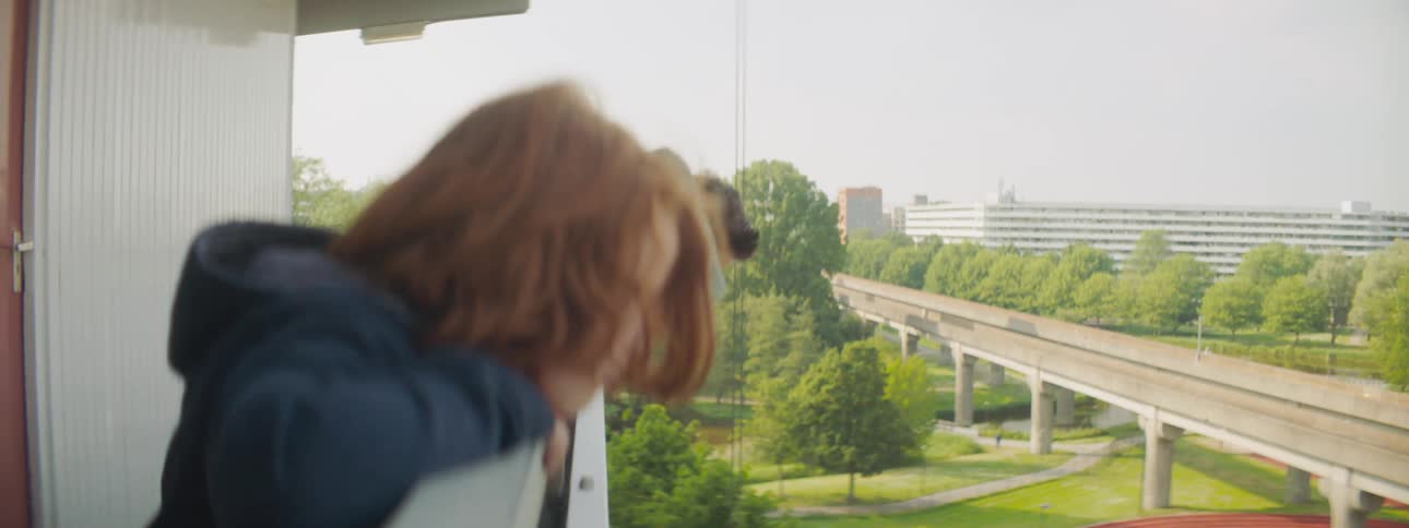 Children standing on a banister spitting with a train trees the sky and clouds in the background