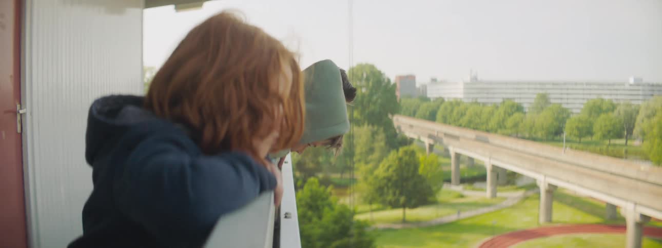 Children stand on top of a balcony and spit directly downwards