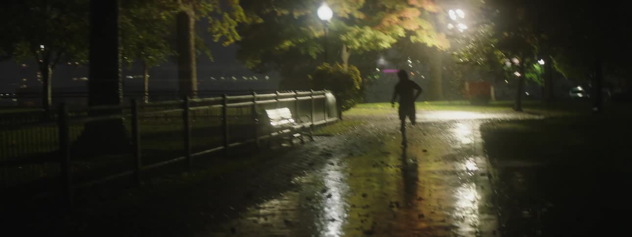 A person is jogging outdoors during the night time