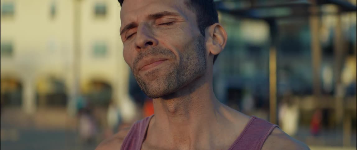A man exhales as he stretches his neck before starting his run