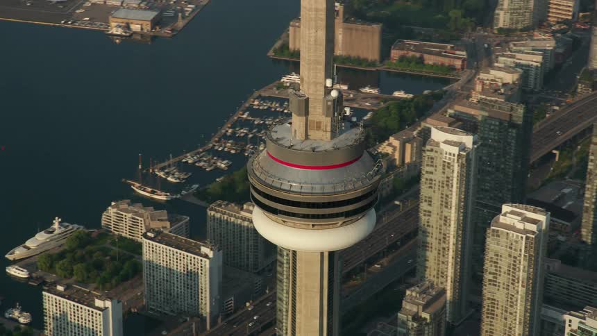 A tower is high in the sky over skyscrapers and a river