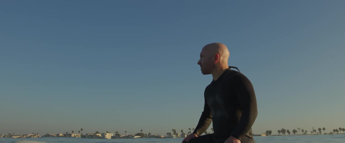 A man sitting on a surfboard in the ocean