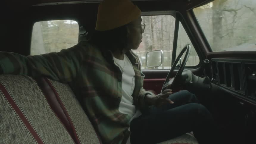 A woman is driving a car in a rural area